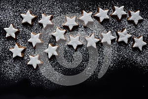 A big Christmas star made of many little biscuits in star shape, against a dark background with space for text