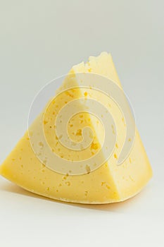 Big Chunk Wedge of Alpine Creamy Appetizing Light Yellow Tilsit Cheese on White Background. Texture with Cracks and Holes