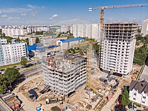 Big city construction site with cranes, machinery and workers