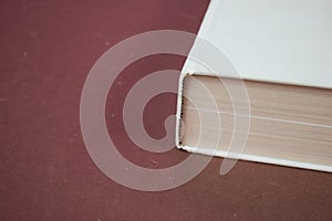 Big closed white hardcover book on red background