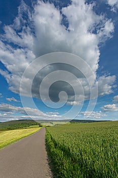 A big cloud 'hanging' in the sky over the fields