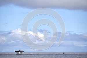 Big clouds and blue sky along the Suffolk coast at Sizewell inlet outlet cooling water tower pier