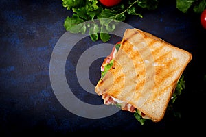 Big Club sandwich with ham, bacon, tomato, cucumber, cheese, eggs and herbs