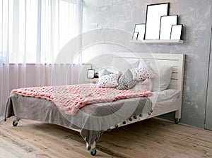 Big comfortable bed in elegant bedroom with set of pillows