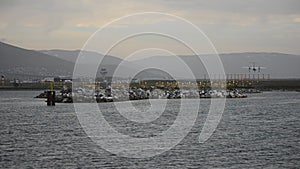 Big commercial airplane coming in for landing over the blue sea on Tromsoe city airport