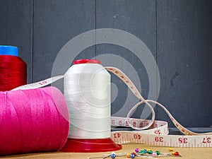 Big cones of thread for sewing and a tape measure