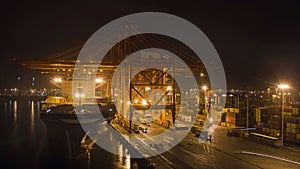 A big container ship is loading cargo in the port