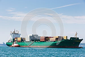 Big container ship with towboat photo