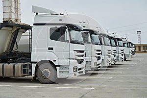 Big container trucks at warehouse building at factory.