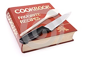 Big cookbook with wooden spoon and kitchen knife