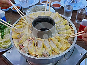 Big cooking hot pot with hot charcoals in the middle, originally from Yunnan, China, adapted and cooked tastier in the North of