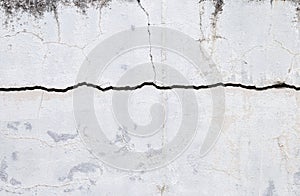 Big crack on old white cement wall background