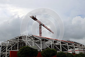 Big crane above the construction of building on cloud and sky background.