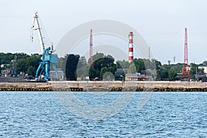 Big crane in dockyard. Large iron navy ships in shipyard for repair. Blue sea harbor