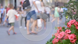 A big crowd of people walking down the street. Out of focus