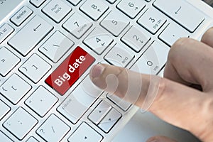 Big data button on white keyboard. Man`s hand on notebook keyboard on a light background. guy presses the enter button