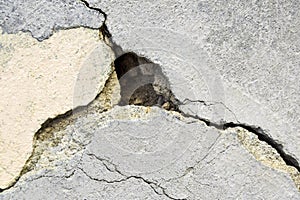 Big deep branched crack on multicolored wall with remnants of old plaster, abstract image of diagonal cleft. Close-up