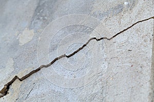 Big deep crack on old concrete wall. Architectural texture.
