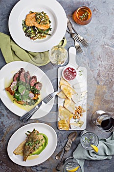 Big dinner table overhead view with steak and fish