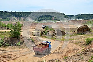 Big dump trucks working in the open-pit.