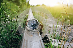 Big elegant men`s watch lying on the railway lines. Stylish fashion accessories outdoors