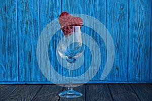 Empty glass glass with red heart on a blue background