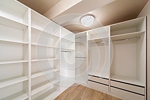 Big empty wardrobe in dressing room. Large wardrobe room, with empty shelves. Interior of modern empty dressing room, wardrobe