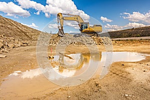 Big excavator moving earth in the construction works of a road