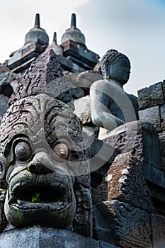 Big Eyed Sculpture and sitting stone Buddha at