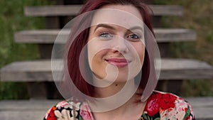 Big eyes of red hair woman looking at camera. Static closeup shot.