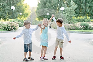 Big family. Brothers and sisters. Children are walking in the park. A group of three children in a summer forest. children play