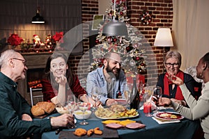 Big family celebrating christmas, talking at festive dinner table