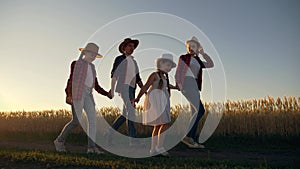 Big family dad mom and daughters have fun in the park. Happy children walk with their parents in the evening at sunset