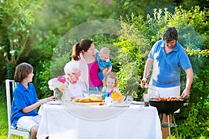 Big family grilling meat for lunch