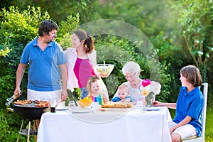 Big family grilling meat for lunch with grandmother