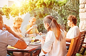 Big family have dinner on open garden terrace