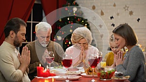 Big family having traditional Xmas dinner, decorations sparkling on background