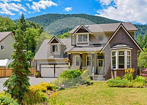 Big family house with concrete driveway, two garage doors, decorated front yard