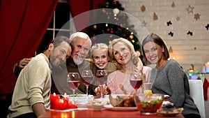 Big family hugging, smiling and looking to camera at Christmas dinner, portrait