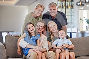 Big family, love and smile of children, parents and grandparent sharing a bond and support while sitting on sofa at home