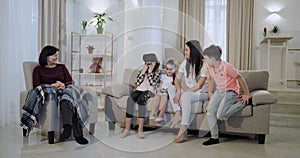 A big family mother three kids and granny spending a nice time together exploring new technology virtual reality glasses