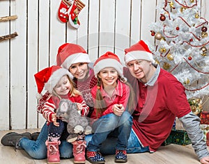Big family in red santa hats near the christmas tree