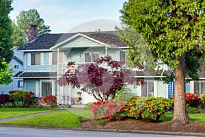 Big family residential house with landscaped front yard and trees