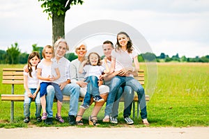 Big Family Sitting On A Bench