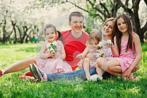 Big family with three little daughters spending time together in summer park photo