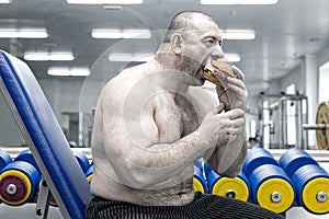 A big fat hungry man eats a hamburger with meat and cheese