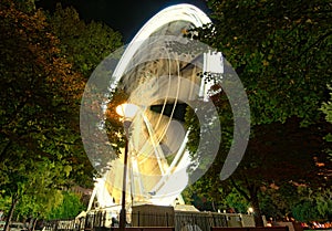 Big ferris wheel Budapest Eye at city park. Budapest Eye at night. Tree Leaves Border. Natural Frame. Colorful light trails with