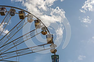 Big ferris wheel in front of blue sky at a folk festival