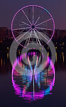 Big ferris wheel at night. Colorful reflection on the lake.