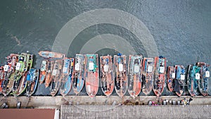 Big fishing boats standing at the sea in Phuket, Thailand. Aerial view from flying drone